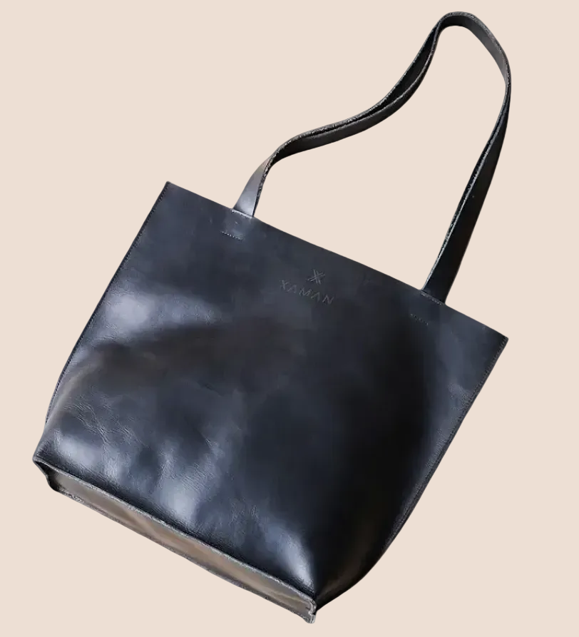 Black leather tote bag on a brown background