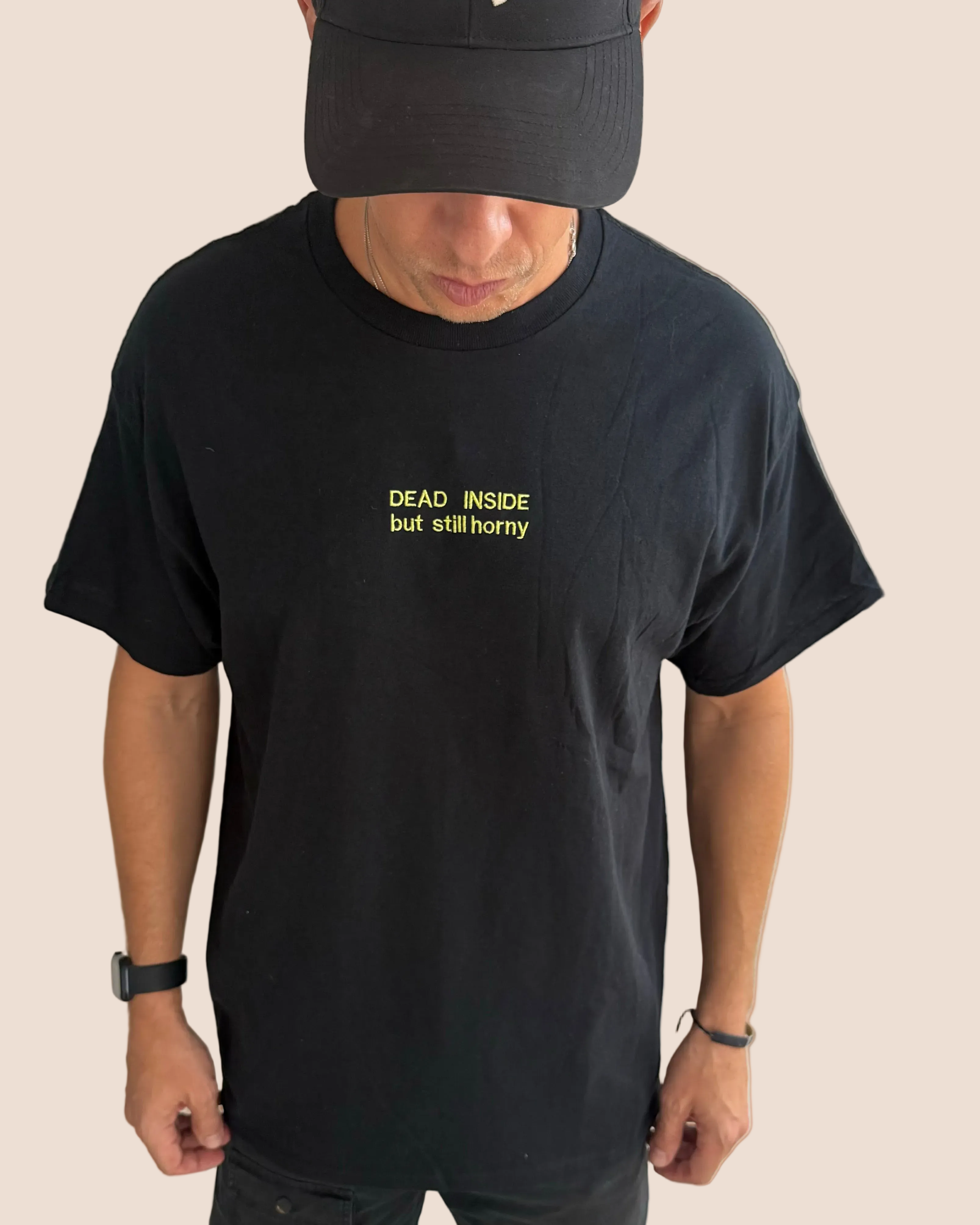 Person wearing a black t-shirt with yellow text on a brown background