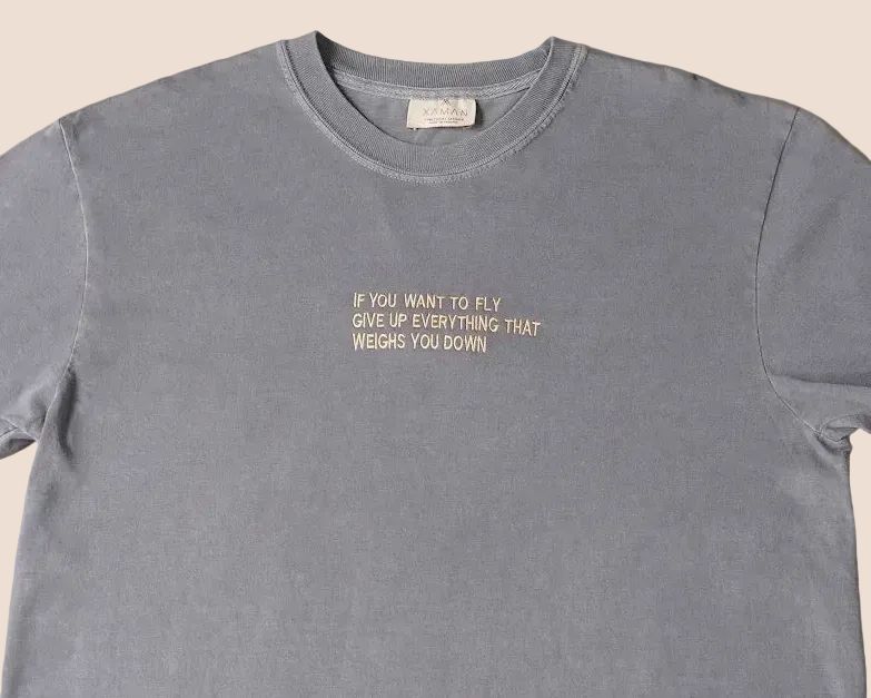 Gray t-shirt with motivational quote on a beige background
