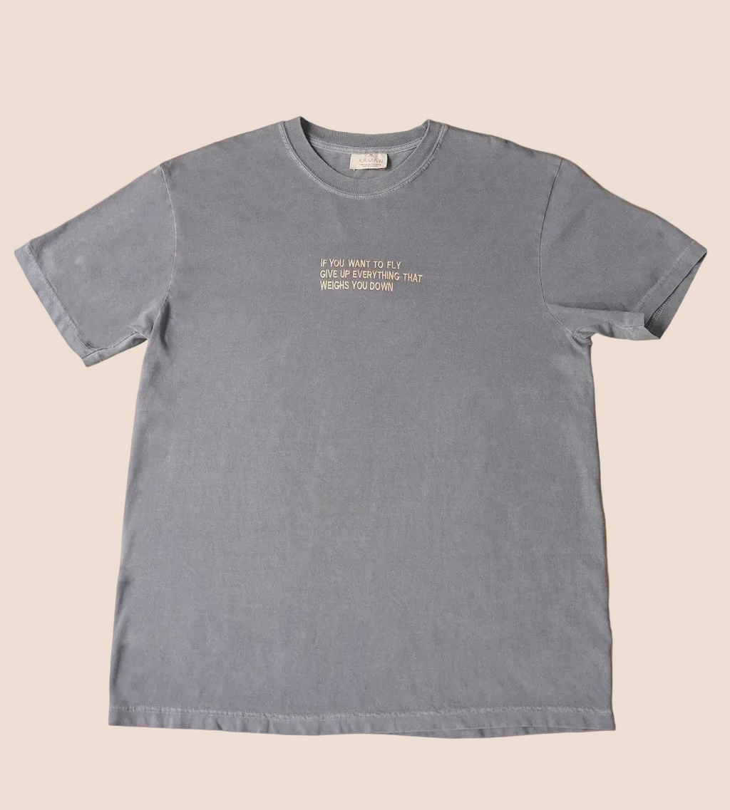 Gray t-shirt with yellow text on a brown background