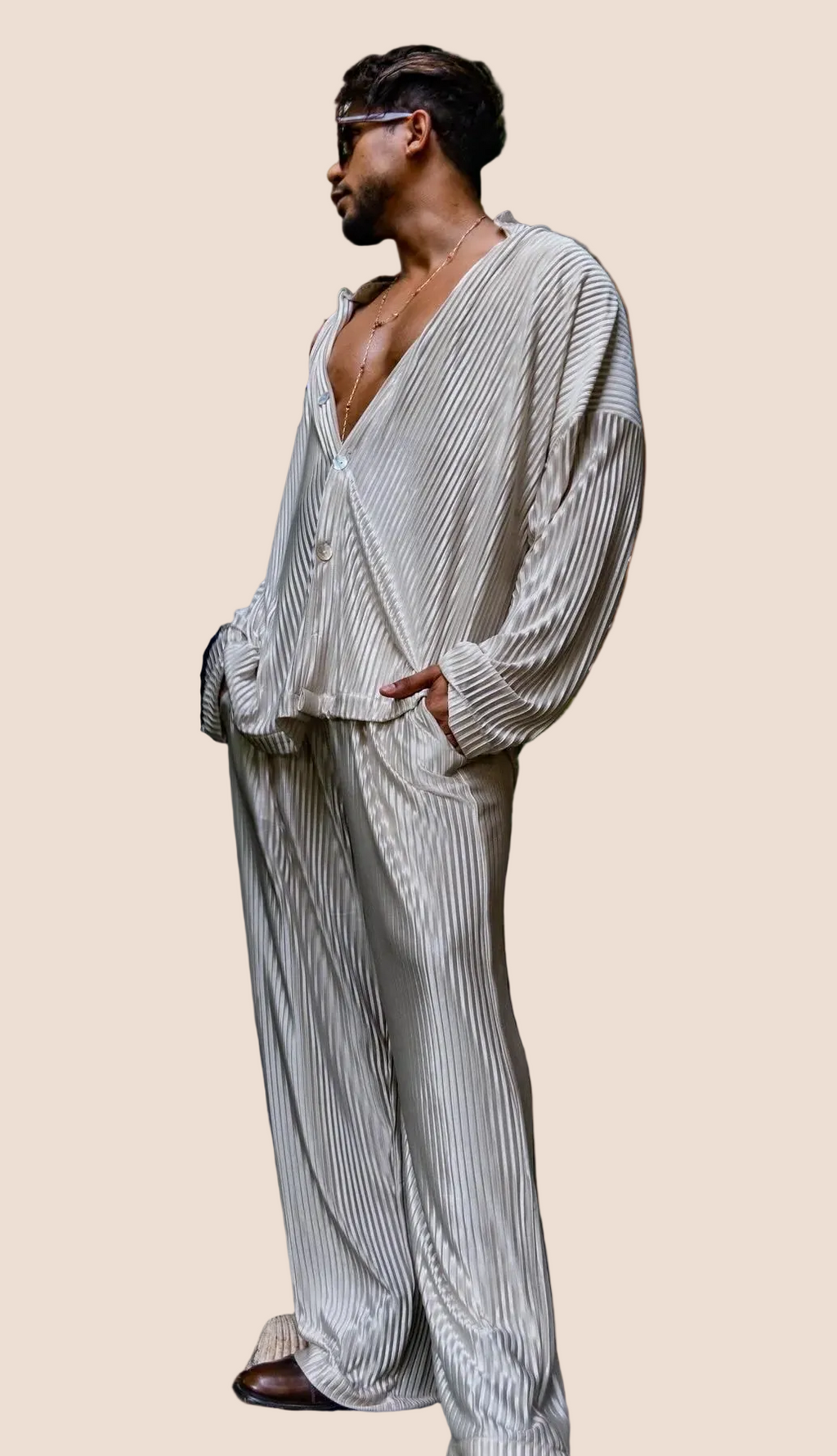 Two models wearing navy blue and beige blue matching silk outfits, standing in a garden setting.