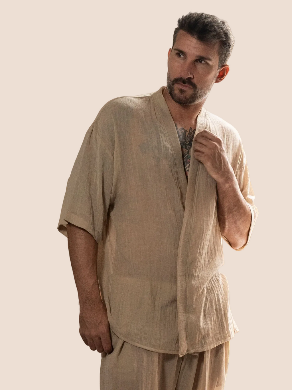 Man wearing a beige outfit against an orange background